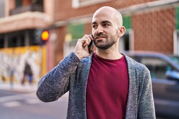 Young man smiling confident talking on the smartphone at street