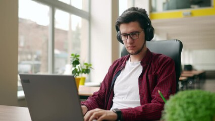 Wall Mural - young stylish customer support service worker removes headphones, looking at camera. office worker t