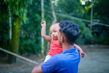 Wall Mural - South asian hindu religious village uncle holding his nephew, young rural  man holding a kid