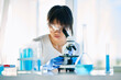© GVS - Portrait of asian scientist looking through a microscope working on medical research in modern laboratory