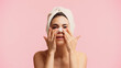 © LIGHTFIELD STUDIOS - young woman with towel on head applying patch on nose isolated on pink