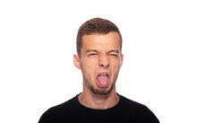 A Young Man And Makes A Disgusted Grimace On A White Background.