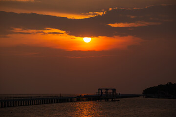 Wall Mural - the sun is shining in the evening moody on the orange sky over the sea