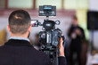 © Alernon77 - A man and a professional camera shoots a conference