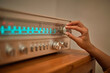 © ADDICTIVE STOCK - Anonymous woman adjusting knob on vintage receiver