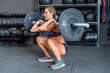 © ADDICTIVE STOCK - Sportswoman doing barbell front squat