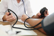 Doctors hand measuring blood pressure of male patient
