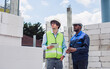 © Ann Rodchua - Two diversity male engineers team working, inspecting outdoor at construction site, wearing hard hats for safety, talking, discussing, using tablet to plan for building. Career, Industry Concept.
