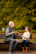 © BGStock72 - Grandfather playing red hands slapping game with his granddaughter in park on autumn day