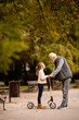 © BGStock72 - Senior man teaching his granddaughter how to ride kick scooter in park