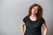 © Artframe  - Happy woman with red curly hair posing on grey background