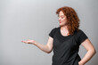 © Artframe  - Happy woman with red curly hair posing on grey background