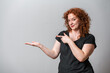 © Artframe  - Happy woman with red curly hair posing on grey background