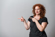 © Artframe  - Happy woman with red curly hair posing on grey background