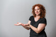 © Artframe  - Happy woman with red curly hair posing on grey background