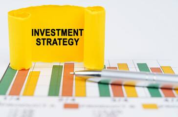 Wall Mural - On the business charts are a pen and a paper plate with the inscription - Investment Strategy