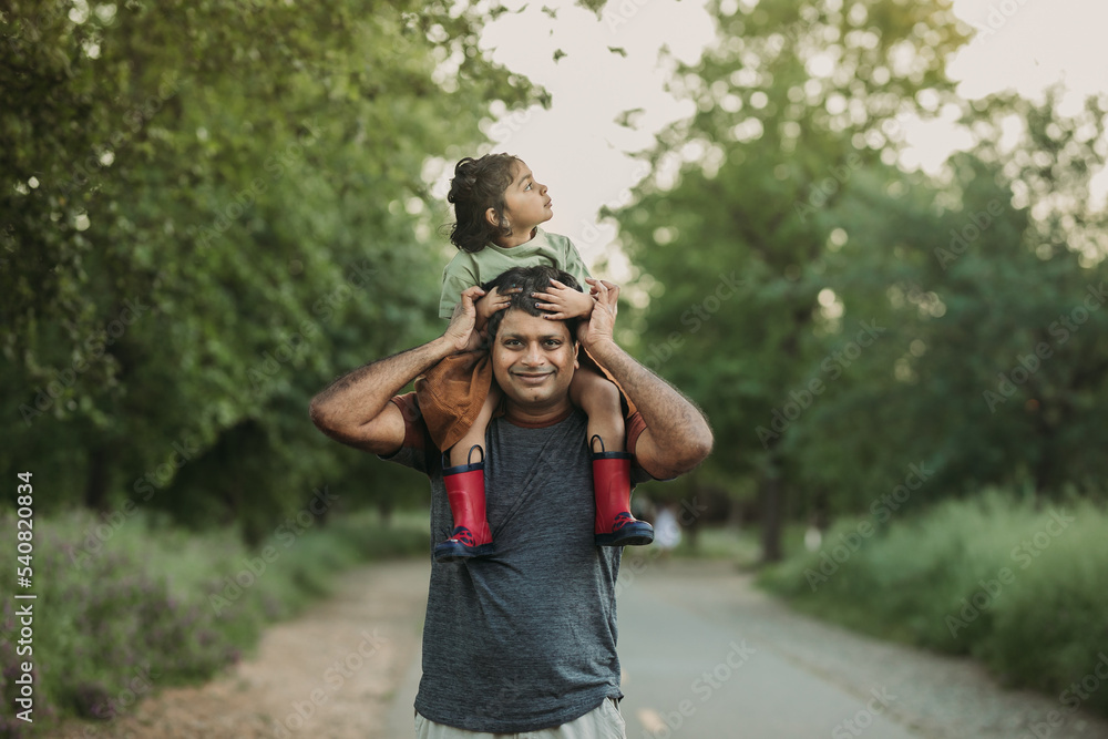 Father carrying her little kid on his shoulders Stock Photo | Adobe Stock