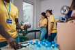 © Zamrznuti tonovi - Group of volunteers working in community charity donation center