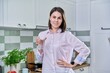 © Valerii Honcharuk - Young smiling woman holding glass of water in kitchen at home