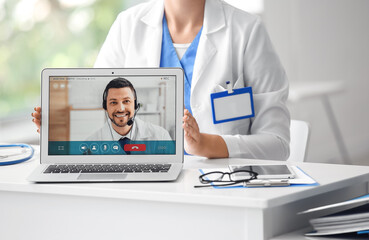 Canvas Print - Doctor video chatting with colleague in medical office