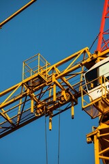 Canvas Print - Yellow construction crane detail and blue sky in the background