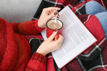 Poster - Woman with cup of coffee reading book, closeup