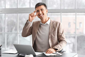 Sticker - Smiling businessman working with laptop at table in office