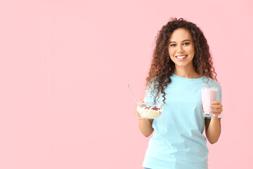 Poster - Happy young African-American woman with healthy food on pink background. Diet concept