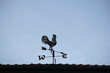 The old wind vane with a rooster symbol icon on the roof, traditional technology equipment for forecast and measuring windy weather in the air, vintage decoration, aiming wind direction instrument.
