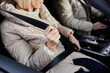 © Seventyfour - Close up of mature woman fastening seat belt in car, copy space