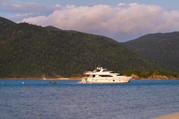 tourist boats and tour boats in the whitsundays queensland, australia. travellers on the great barrier reef, over coral and fish. tourism yachts of young people partying on the water