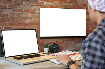 Wall Mural - side view of creative male freelancer working on design project with laptop in home office.