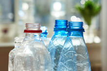 Close-up Of Empty Plastic Bottles Stand On Against The Window