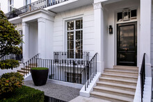 Entrance To A Townhouse With Matching Black Front Doors. Exterior Is White.