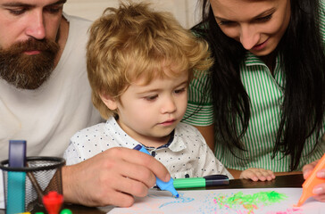 Wall Mural - Parents and little child playing together. Cheerful son drawing with father and mother enjoying spending time. Kid learning painting, little artist painting, drawing.