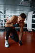 © Nomad_Soul - Portrait of boxer standing on one knee in ring