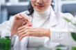 © chokniti - Beauty eco cosmetic research and development concept, Scientist or Pharmacist applying moisturizer lotion on her hand for efficacy testing of natural organic skincare products in laboratory