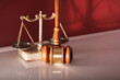 gavel hammer and libra scale against red background