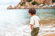 A boy throwing stones on the beach of the port of Sant Miquel, Ibiza Island. Balearic Islands