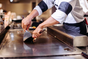 Wall Mural - Hand of man take cooking of meat with vegetable grill, Chef cooking wagyu beef in Japanese teppanyaki restaurant