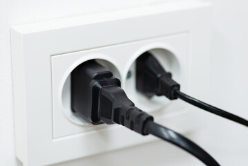 Two plugs in double electric socket. Concept of electricity, electric devices, wall outlet