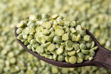 Poster - Spoon with green pea. Close up shot of black wooden spoon with pea grain