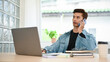 © bongkarn - Professional Asian male office employee talking on the phone with his client while working