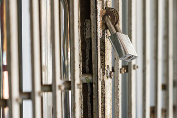 Old master key locked on iron gate, Steel padlock, Close up selective focus