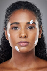 Wall Mural - Beauty, face and skincare cream with black woman in a studio for wellness, grooming and hygiene against grey background. Portrait, model and sunscreen product for cosmetic, dermatology and facial