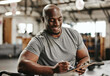 © Siphosethu Fanti/peopleimages.com - Gym, workout and personal trainer with checklist on clipboard consulting for training sports in gym. Black man of muscular, active and smiling fitness coach writing on health, wellness and exercise