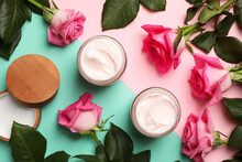 Glass Jars Of Face Cream And Roses On Color Background, Flat Lay