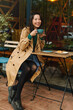 © olga pink - Portrait of young attractive Asian woman drinking coffee witn apple pie in cafe on terrace of cafe