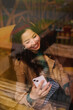 © olga pink - Looking through the window. Portrait of young Asian woman taking selfie in cafe