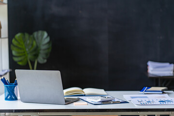 business office with laptop, financial documents, calculator on the table
